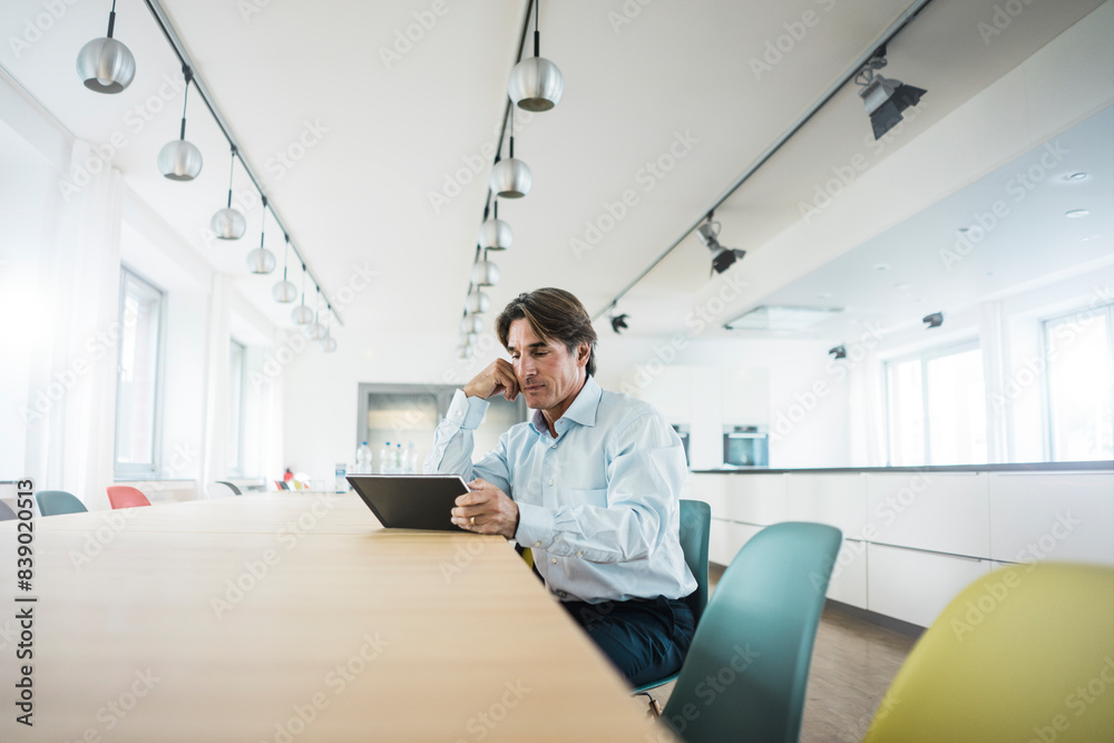 Poster Businessman using tablet at table in office