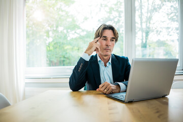 Businessman using laptop at table in office