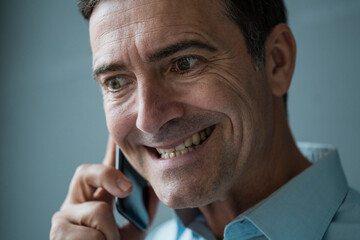 Portrait of grimacing businessman on cell phone