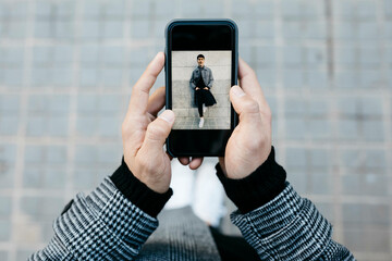 Man holding smartphone with photo of himself, close-up