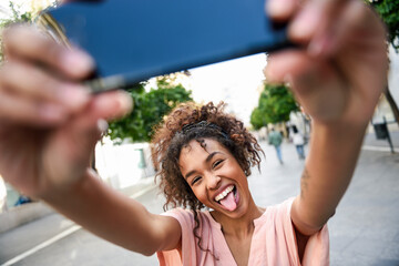 Carefree young woman taking a selfie in the city