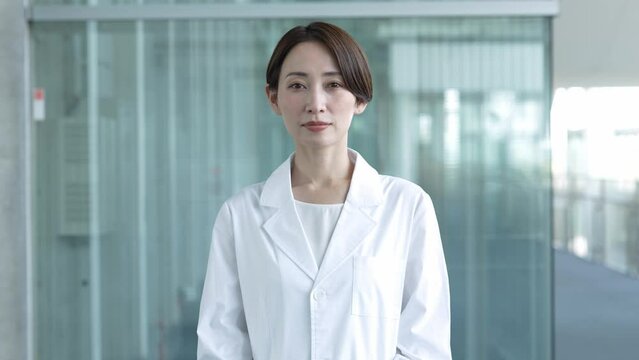 カメラ目線で真剣な表情の白衣を着た女性