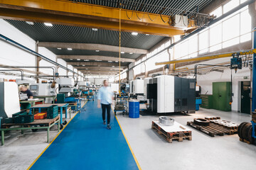 Businessman walking through factory workshop