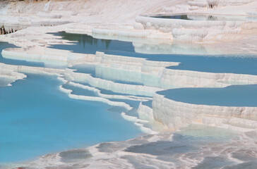 Photo with a view of snow-white travertines filled with blue water in Pamukkale, Denizli, Turkey	
