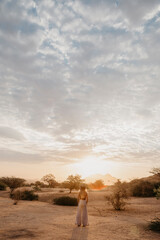 Namibia, Spitzkoppe, woman standing in desert landscape at sunset