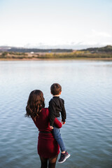 Mother and son looking at lake, rear view