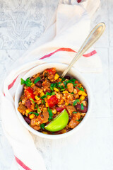 Bowl of vegetarian chili with tofu, corn, kidney and pinto beans, cilantro and lime