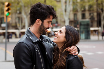 Spain, Barcelona, happy young couple hugging on the street