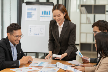 Asian business group discussing graph work at the office