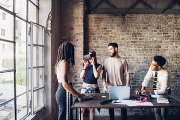 Creative team using Vr goggles in loft office