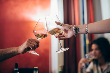 Cropped image of friends toasting wineglasses during party at home