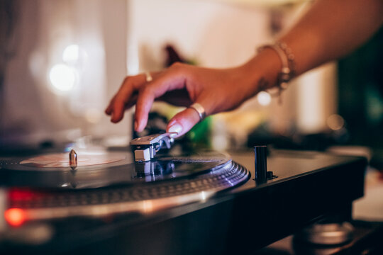 Cropped image of woman using turntable during party at home - Powered by Adobe