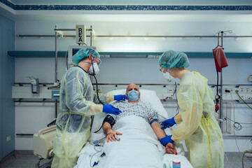 Doctors caring for patient in emergency care unit of a hospital taking blood sample