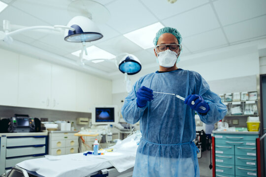 Emergeny doctor putting a swab into a tube in hospital