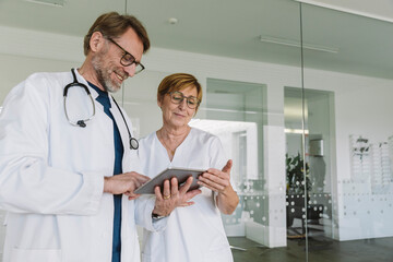 Doctor and assistant using tablet in medical practice