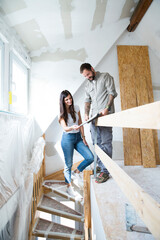 Couple in attic to be renovated looking in catalgue