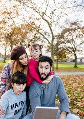 Family with tablet in autumnal park