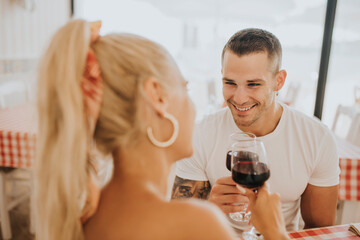 Happy young couple toasting wineglasses in restaurant