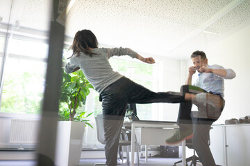 Businessman and businesswoman fighting in office