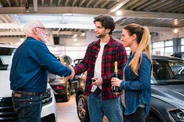 Couple buying new car at car dealership