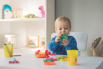 Portrait of baby girl playing with cutter and modeling clay