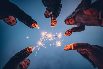 Five children holding sprklers against evening sky