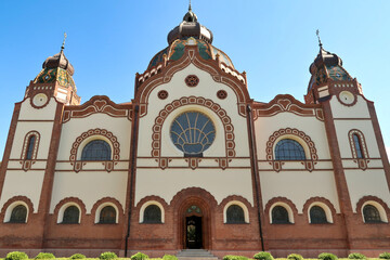 The complete facade around the side entrance of the Synagogue of Subotica on a sunny day with blue...