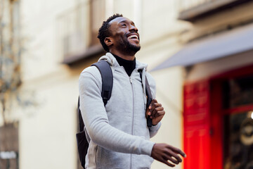 Smiling man carrying backpack while walking outdoors