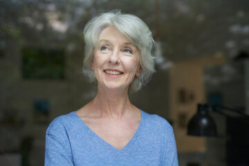 Portrait of content mature woman looking out of window