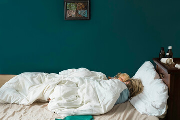 Sick girl lying in bed with doll