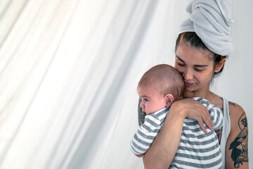 Tattooed young woman holding her baby