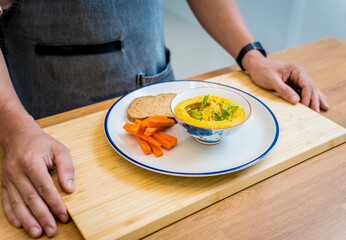 Chef at the kitchen preparing chickpea porridge with ginger