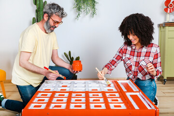 Couple painting furniture with brush at home