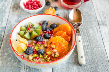 Superfood breakfast with porridge, amaranth, various fruits and pistachios