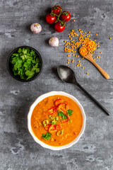 Soup bowl of garnished red lentil soup and ingredients