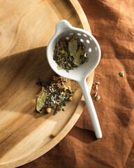 herbal tea made from large herbs in a ceramic strainer