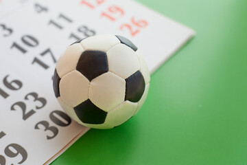 Football ball on the calendar and green background close-up, close-up of a football ball, sports...
