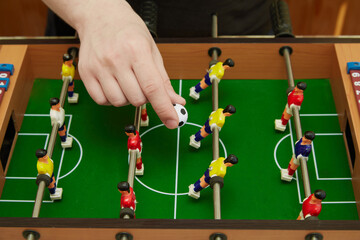 Arm throwing the ball in on a game of foosball, sports foosball board game, start of the game