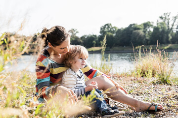 Mother and son sitting at the riverside