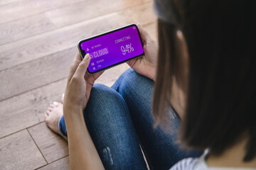 Young woman with smartphone with smart home control functions