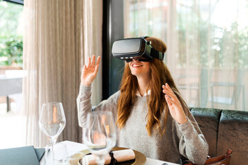 Woman sitting at table in a restaurant wearing VR glasses