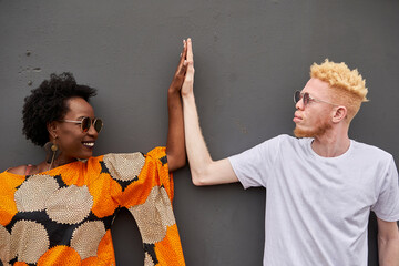 Couple joining hands in front of grey background