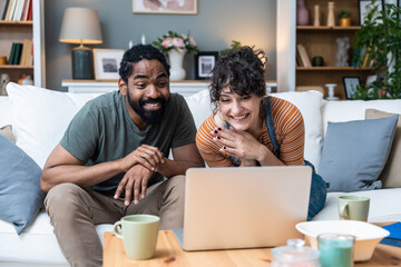 Young freelance workers couple man and woman having video call on laptop with customer or client....