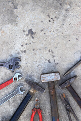 Old working tools on a concrete surface, top view. Hammers, sledgehammer, metal shears, adjustable wrench and wrench. Hand tool. Builder's Day or Father's Day. Construction and renovation concept