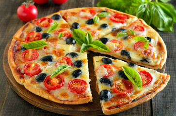 Sliced pizza with tomato and olives