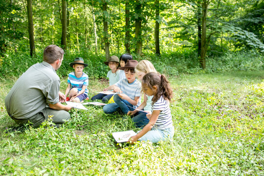 School children learning to distinguish animal species in forest