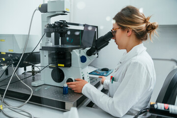 Laboratory technician using microscope in lab