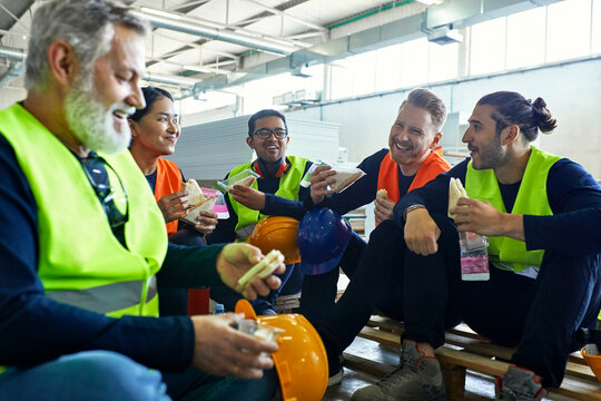 Happy workers in factory having lunch break together - Powered by Adobe