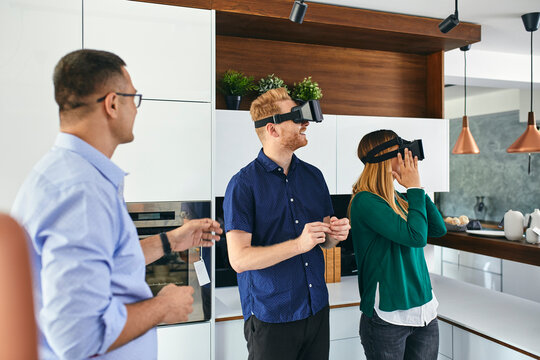 Couple wearing VR glasses shopping for a new kitchen in showroom