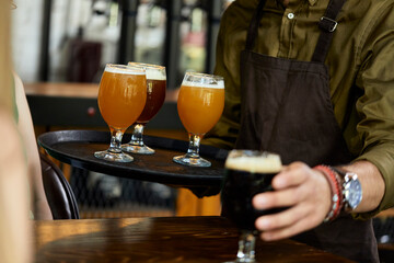 Waiter serving variety of craft beer in a pub